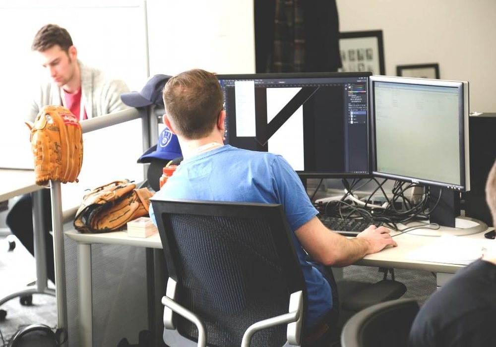 Technicians working at computer workstations in a service office