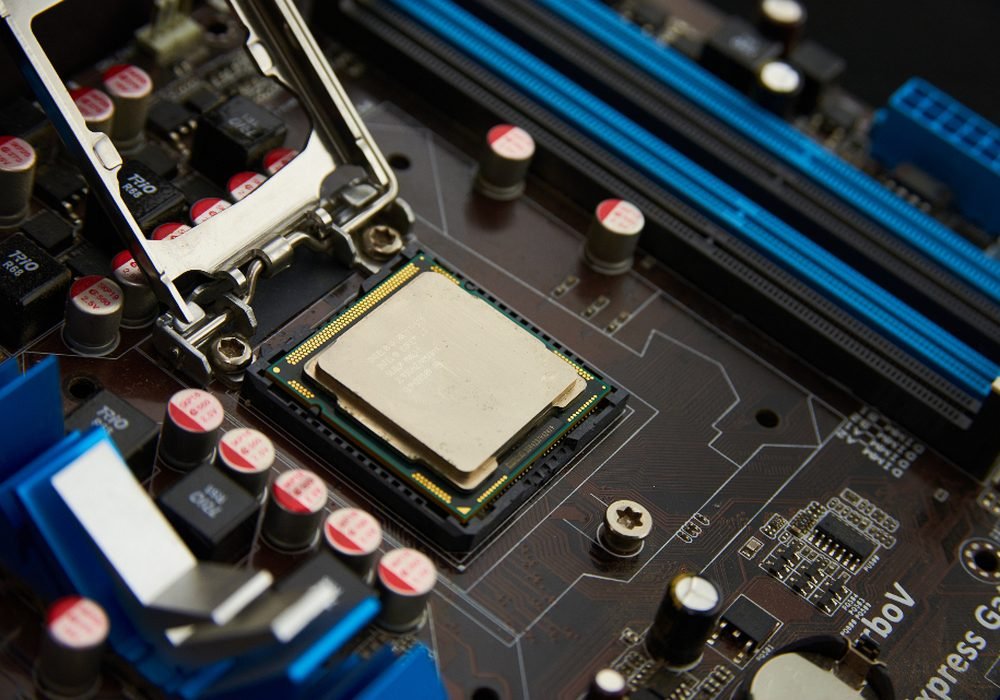 Desktop motherboard with CPU socket open on a repair bench