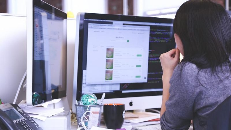 Office worker at a dual-monitor workstation