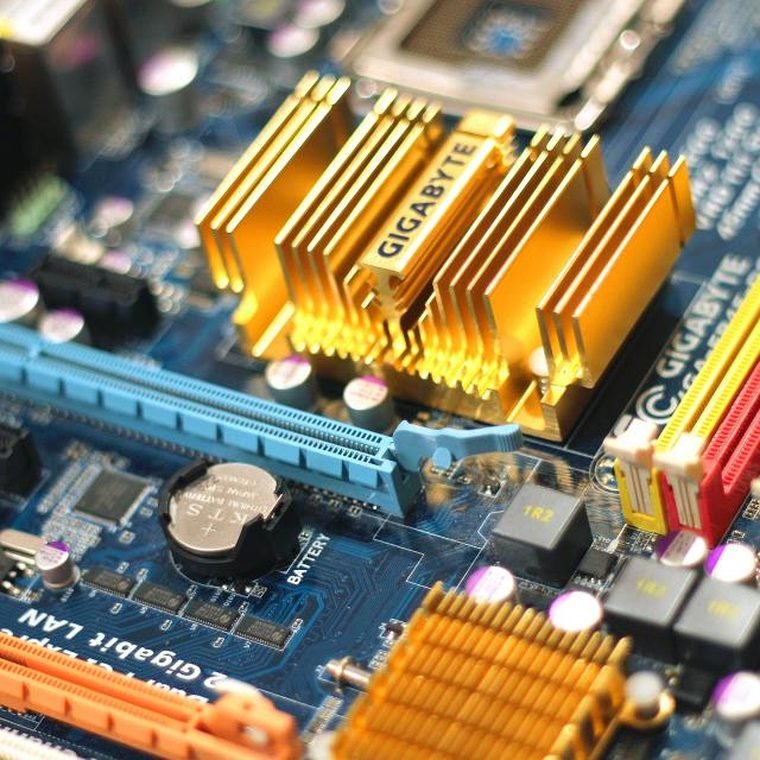 Close-up of a desktop motherboard during component-level repair